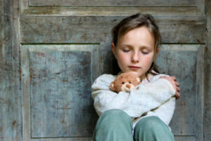 Sad little girl with teddy bear
